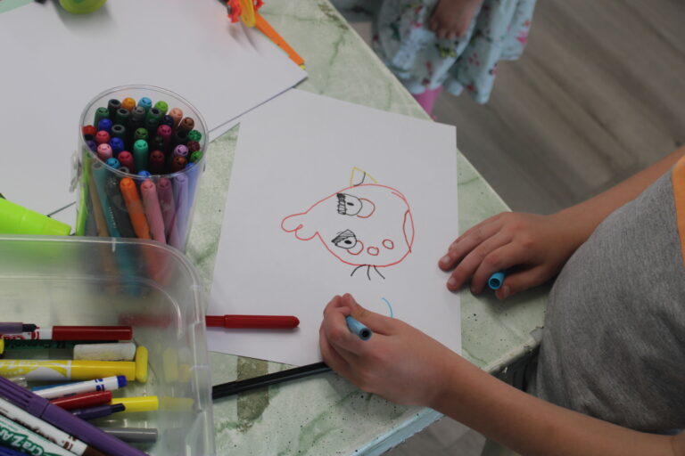 A Young Person making a crayon drawing